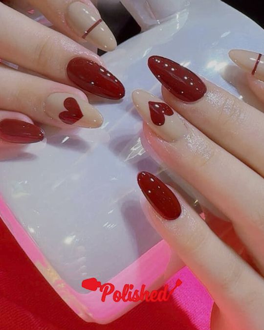Almond-shaped nails featuring a mix of deep red and nude polish
