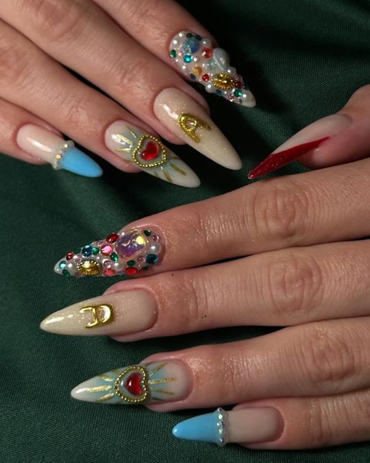 A captivating blend of colors, gems, and heart designs adorn these stylish stiletto nails.