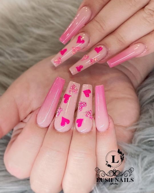 Long coffin nails featuring a soft pink ombré effect with pink hearts