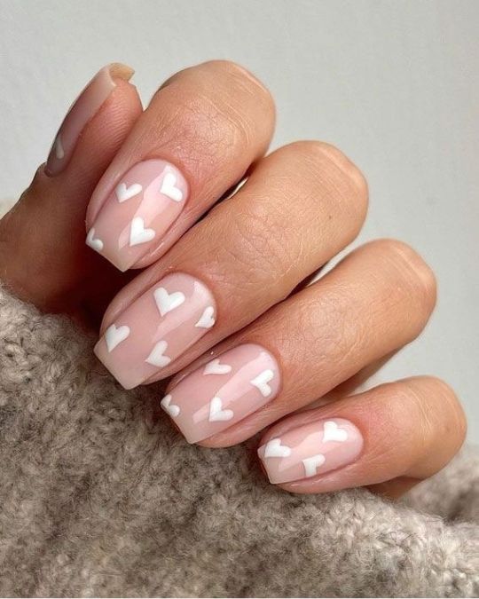 soft pink nails adorned with delicate white hearts