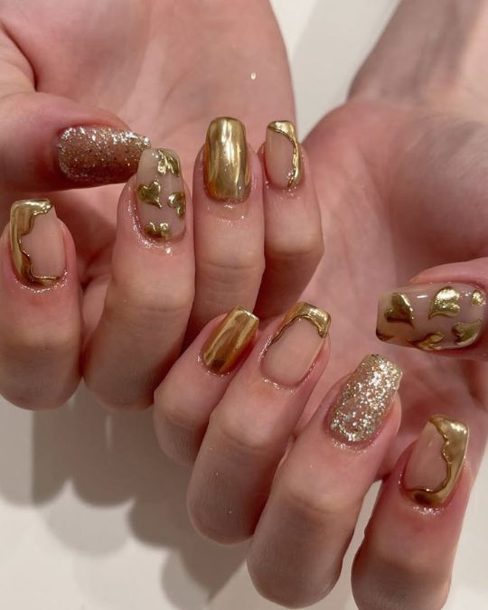Golden Glamour squoval nails with glitter accents radiate luxury and warmth