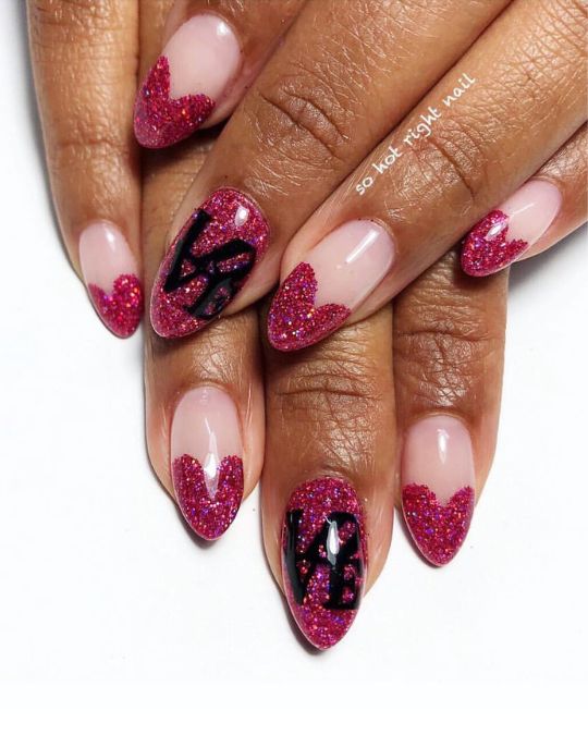 Almond-shaped nails featuring soft pink bases with glittering fuchsia heart tips and "LOVE" accents