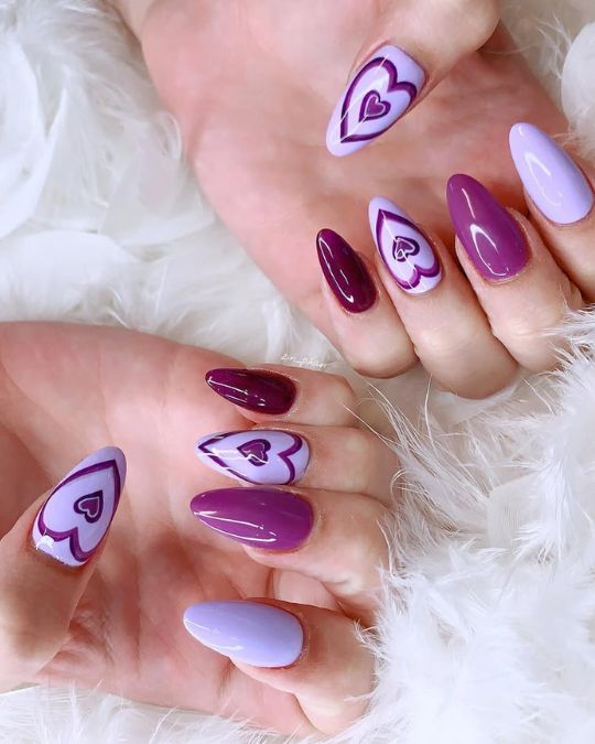 Elegant almond nails blend soft lavender and deep plum, featuring nested heart designs